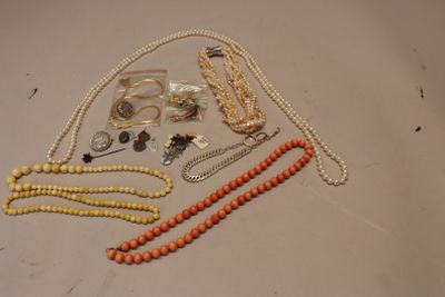 many different necklaces and bracelets laid out on a table