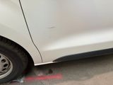 a small white car with a flat tire on the street