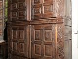 une commode en bois dans une pièce, sur laquelle est posée une horloge