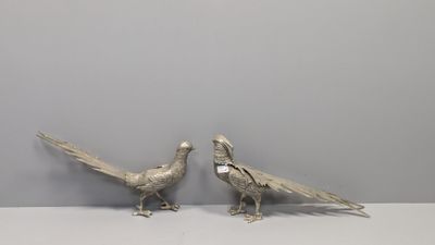 paire de faisans anciens en métal argenté posés sur une table blanche