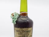 une image représentant une bouteille d'alcool surmontée d'une grenouille