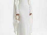 une femme en robe blanche, avec une cape sur les épaules