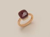 a close up of a ring with a red stone on it