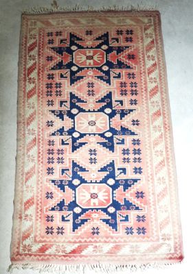 un vieux tapis orné d'un motif bleu et rose