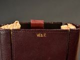 someone is holding a wallet with a cell phone inside of it