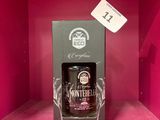 une bouteille d'alcool dans un coffret posé sur un support rose
