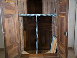 a wooden cabinet with a door open on a tiled floor