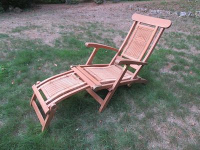 une chaise de jardin en bois posée dans l'herbe