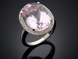 an oval pink sapphire and diamond ring on a black surface