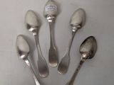 six silver spoons are arranged in a circle on a white surface