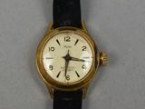 a gold wrist watch with a white face on a black strap