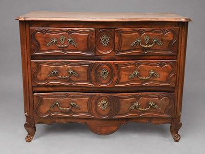 une commode en bois dont les tiroirs sont ornés de sculptures élaborées