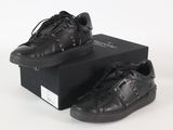 Il s'agit de deux paires de baskets noires ornées de clous.