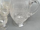 a lot of glasses and a pitcher on the table