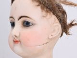 a small doll with a very long hair on it ' s head
