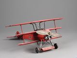 un petit avion rouge posé sur une surface grise
