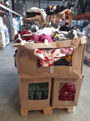 une boîte en carton sur laquelle sont posés des vêtements, dans un entrepôt