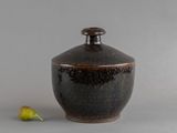 un petit vase avec une poire sur la table