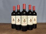 four bottles of red wine are lined up on a wooden table