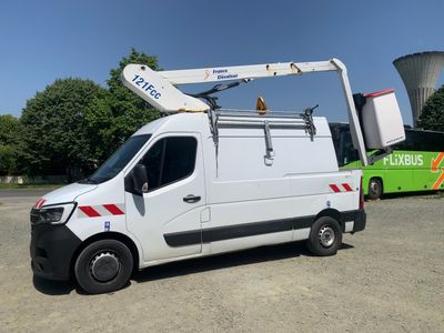 a white van parked in a parking lot with a green bus in the background