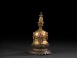 a gold statue of a buddha on a pedestal with a black background