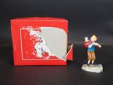une petite figurine représentant un garçon tenant une batte de baseball