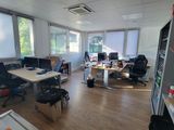 une salle où se trouvent de nombreux bureaux et chaises