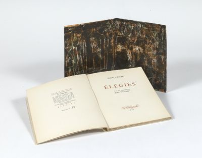un livre ouvert posé sur une table blanche à côté d'un livre