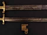 two knives that are laying on a black surface