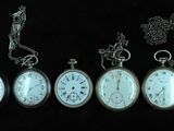 five different types of pocket watches on a black background