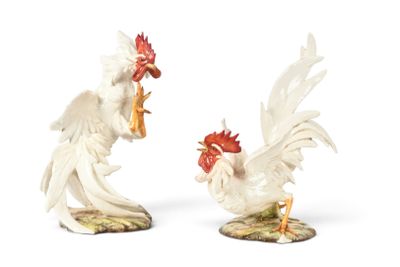 two figurines of a rooster and a chicken on a table