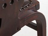 the back of a wooden chair with holes in the seat
