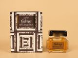 gros plan d'un flacon de parfum à côté d'une boîte