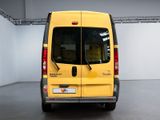 the back of a yellow van parked inside of a building