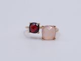 a pair of pink and red stone rings on a white surface