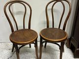two wooden chairs sitting next to each other on the floor