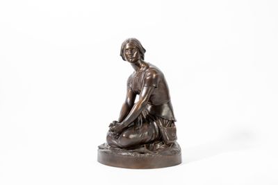 statue en bronze représentant une femme assise sur un rocher, sur fond blanc