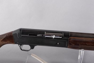 un gros plan d'un fusil exposé sur un socle transparent