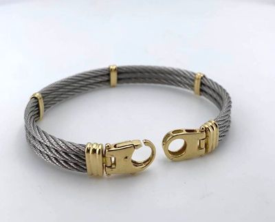 a cable bracelet with two gold clasps on a white surface