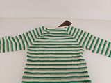 a green and white striped dress sitting on top of a white table