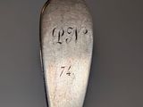 a silver spoon with writing on it on a table
