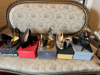 many pairs of shoes sitting on a chair in a room
