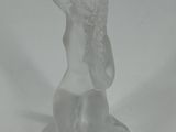 a glass figurine of a woman with a hat on her head