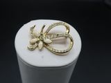 gold tone bow brooch with rhines on top of a white box