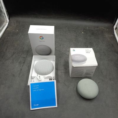 un carton contenant des enceintes Google Home Mini et un carton contenant des enceintes Google Home Mini