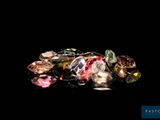 several different colored diamonds are on a black surface