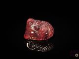 gros plan d'un diamant rouge sur une surface noire