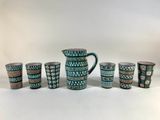 a set of six green and white cups and a pitcher
