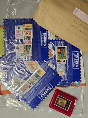 un sachet de timbres et des timbres posés sur une table