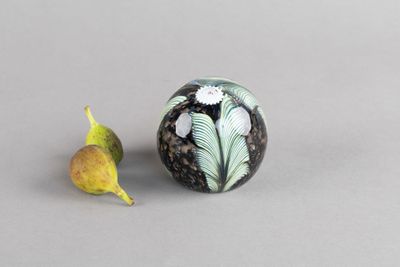 une boule en marbre noir et blanc sur laquelle est représentée une feuille